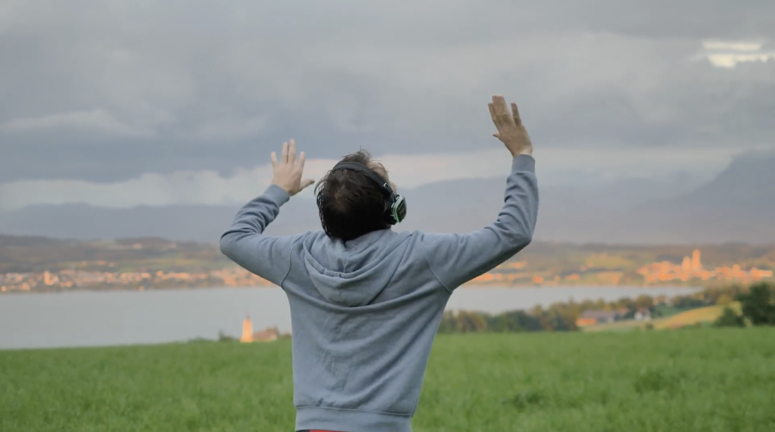 Menschen tanzen mit Kopfhörern in der Natur bei goldenem Abendlicht