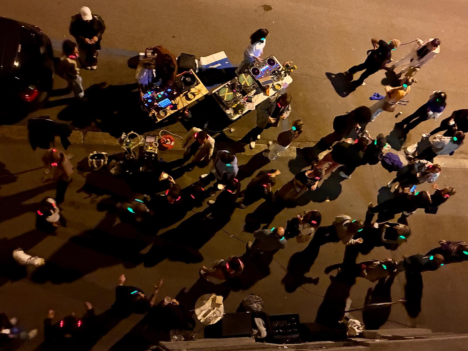 Tanzende Menschen mit leuchtenden Silent-Disco-Kopfhörern auf einem Parkplatz in Zürich